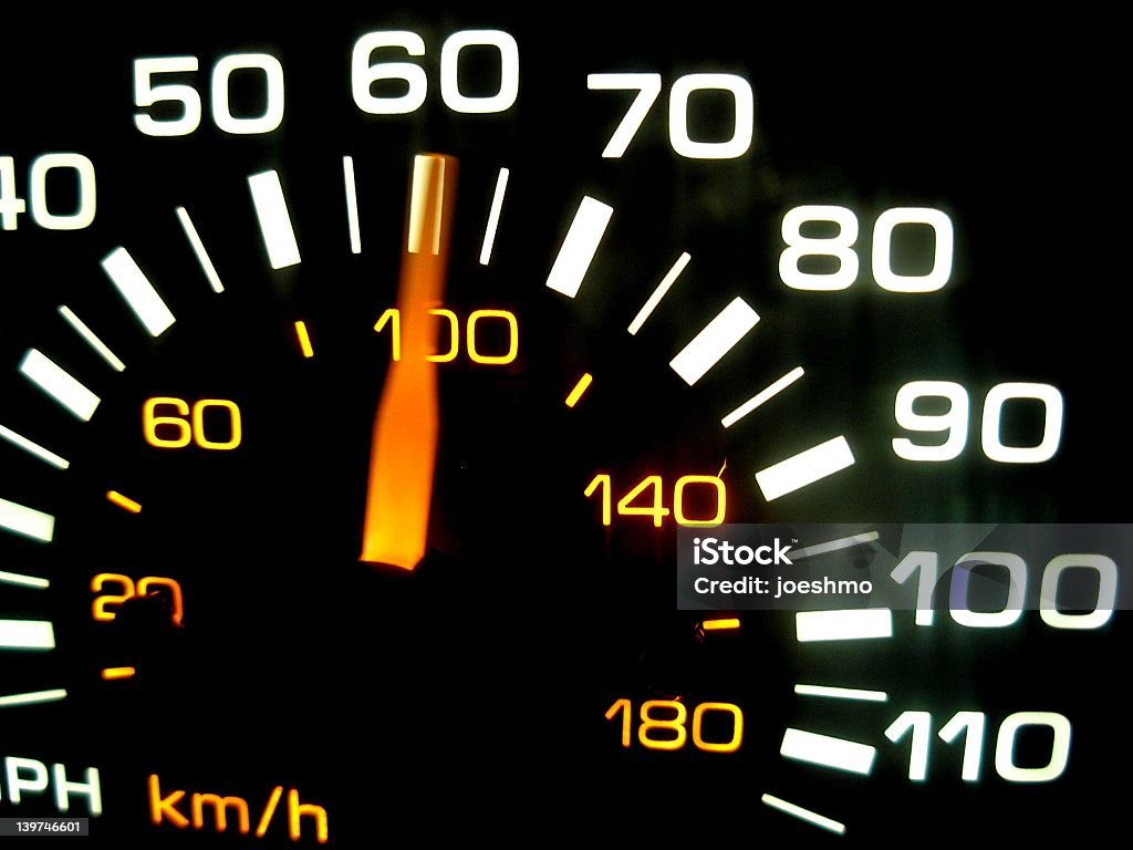 A close up of a car speedometer A speedometer races past sixty mph. Speed Stock Photo