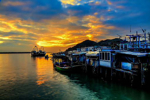 The sunset glowed red in Tin houses built in water of the fishing village and the nearby sea.
