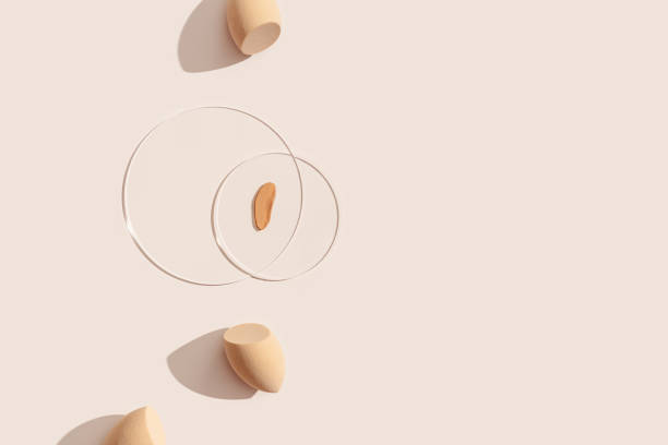 istock Makeup sponges for foundation cream, samples on glass disk on beige color background with shadows. Skincare beauty blender. Flat lay swatches from tone cream and sponge, aesthetic trends 1397468752