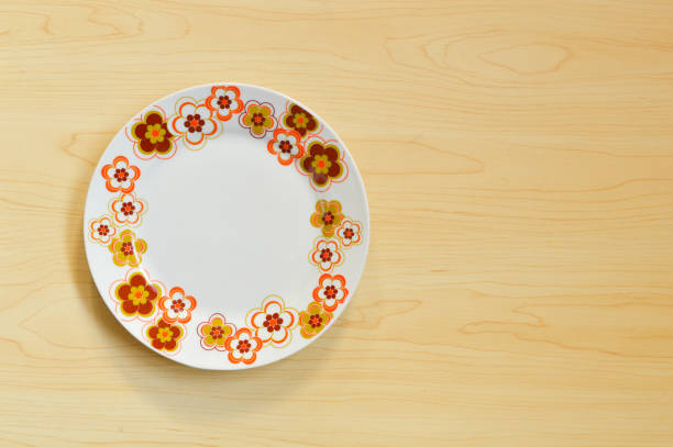 White plate isolated on wooden background
