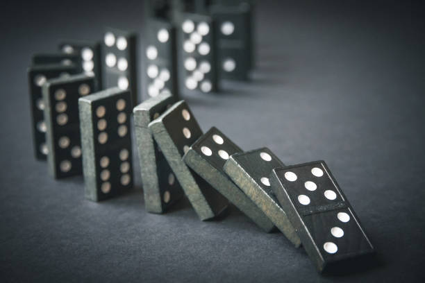 istock Black dominoes chain on dark table background 1397469504