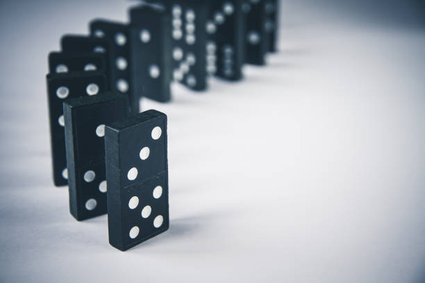 istock Black dominoes chain on white table background 1397469510