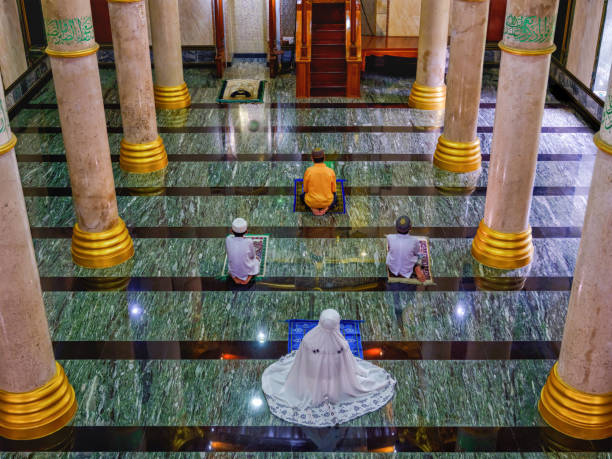 muslim people man, boy and woman in hijab sitting together in mosque for praying  and having islamic celemony