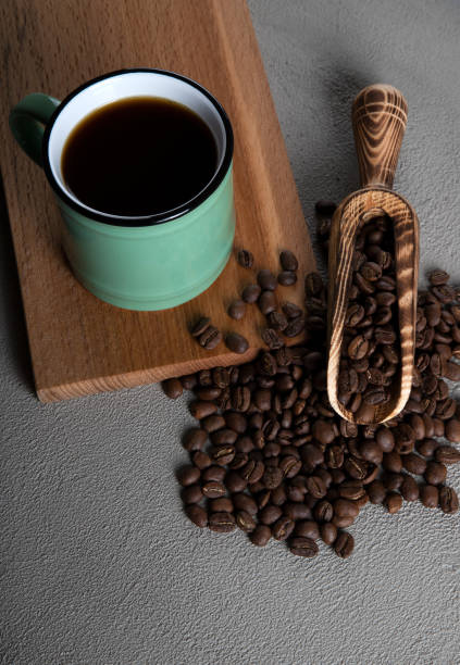 istock Green cup of coffee with coffee beans on concrete background 1397472181