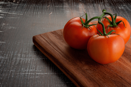 Fresh Tomato on Wooden Board. Wallpaper for Healthy Food Thematic Background.