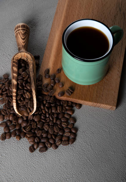 istock Green cup of coffee with coffee beans on concrete background 1397473928