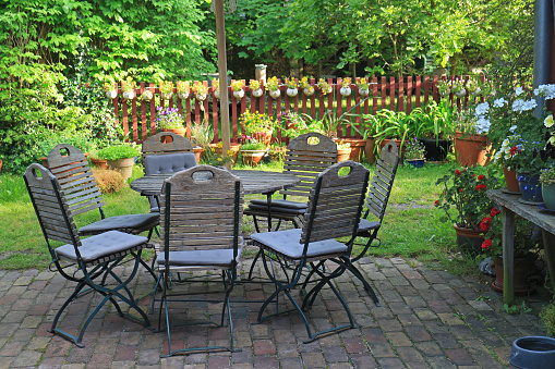 Wooden outdoor furniture on the patio in the backyard garden