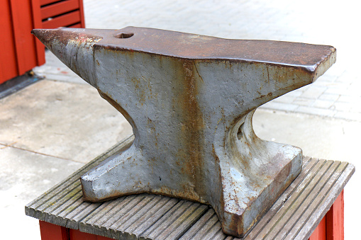Old steel anvil on wooden platform