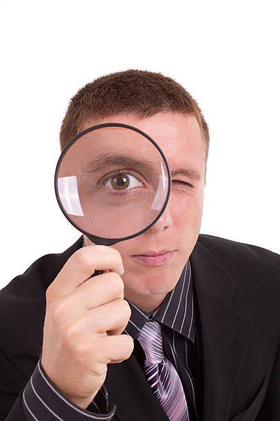 istock Close-up man looking through magnifying glass 139747649