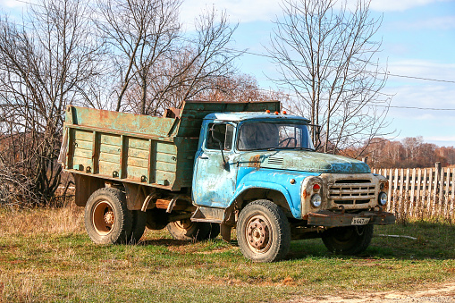 Ustyugovka, Russia - October 17, 2021: Rusty Soviet dump truck ZiL-MMZ-4502 in a village street.