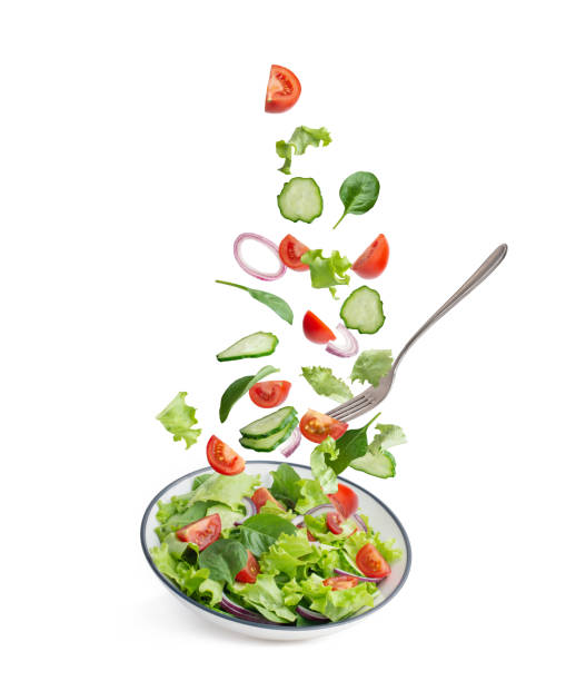 istock green salad falling into a plate on a white background 1397479623