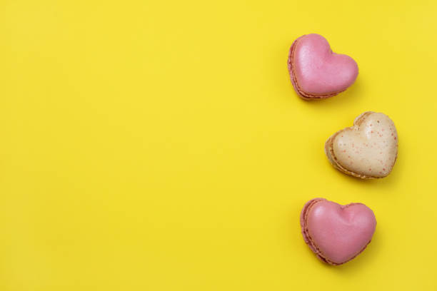 istock Heart shaped macarons on yellow background 1397480606