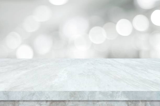 istock Empty white table top, counter, desk over blur perspective store with bokeh light background, White marble stone table, shelf and blurred shop for food, product display mockup, template backdrop, banner, Retail business wallpaper, poster 1397480626