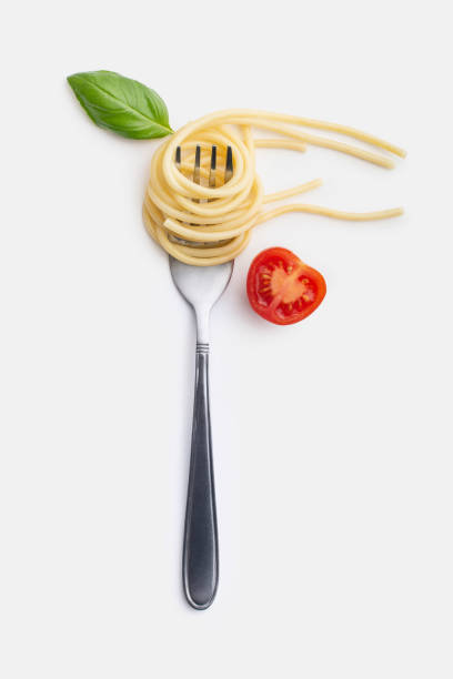 istock Pasta with tomatoes and basil on a fork. White isolated background. 1397480755