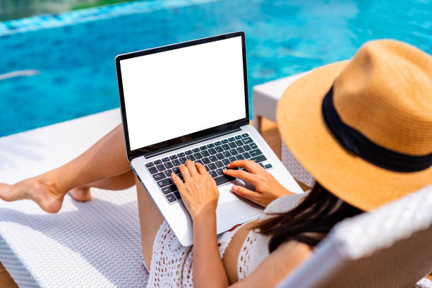 Young woman freelancer traveler working online using laptop while traveling on summer vacation, Freelance and workation concept stock photo