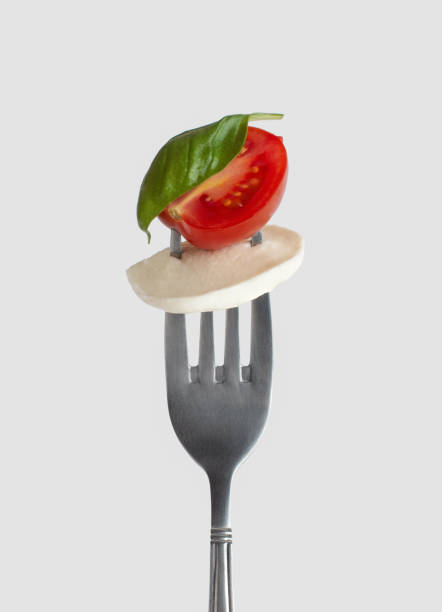 istock green salad with tomatoes and mozzarella on a fork on a white background 1397482825