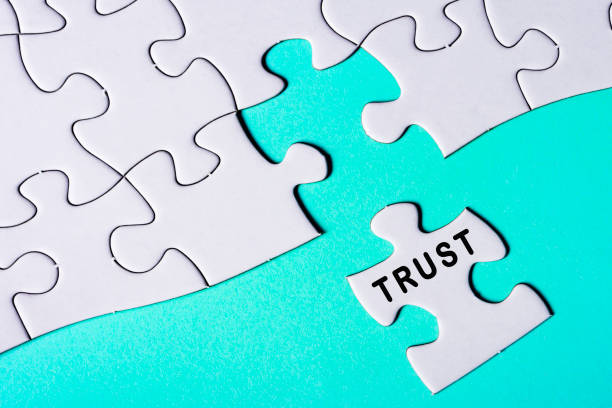 istock White jigsaw puzzle with word trust over blue background. Business concept. 1397483724