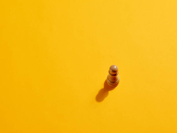 istock Pawn chess piece on yellow background 1397484965
