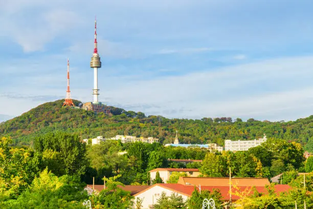 Wonderful view of Namsan Seoul Tower on Namsan Mountain in Seoul, South Korea. The tower is a popular tourist attraction of Asia. Scenic sunny cityscape.