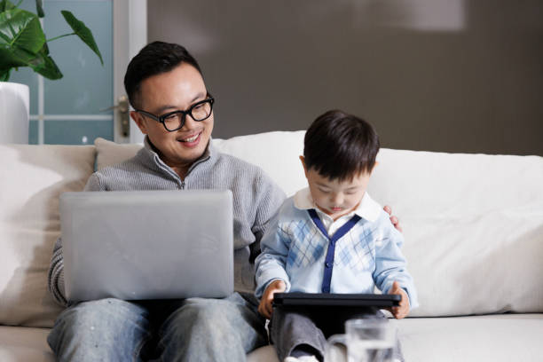 istock A middle-aged Asian man works at home with his son 1397485703