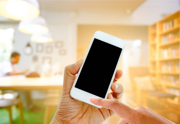 hand hold and touch screen smart phone on blurred man with laptop at cafe background with burst light, business , technology concept