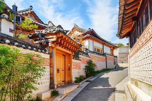 Deserted old narrow street and traditional Korean houses of Bukchon Hanok Village in Seoul, South Korea. Beautiful cityscape on sunny day. Seoul is a popular tourist destination of Asia.