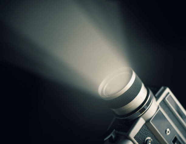 Vintage film camera with spotlight over black background.