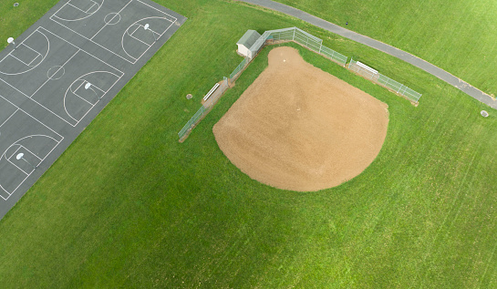 Aerial view of asphalt basketball courts and a baseball field.