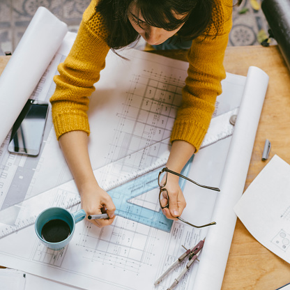 Real estate creative studio office. Top view of architect woman working on architectural project for interior design.