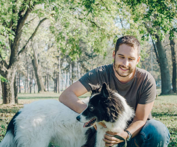 homme avec son chien jouant dans le parc - dog retrieving german shepherd pets photos et images de collection