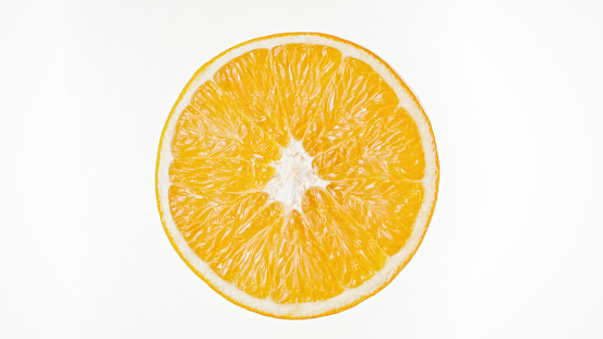 Close-up of half orange fruit against white background.
