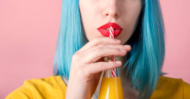 donna che beve succo d'arancia - human lips orange lipstick human mouth foto e immagini stock