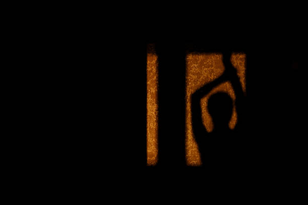 Shade silhouette woman on wall at home in evening sunlight. shadow of girl dancing with hand up. Concept of rest, home, joy, lifestyle, freedom