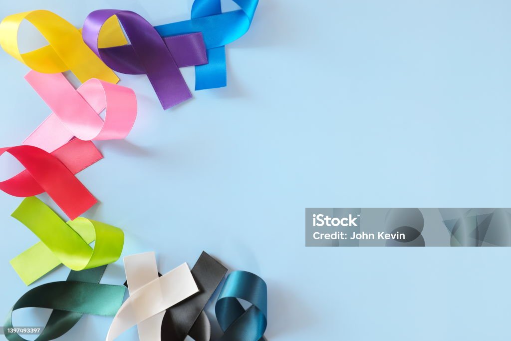 Set of colorful cancer awareness ribbons flat lay in blue background. World Cancer Day concept. Cancer - Illness Stock Photo