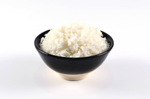 istock Rice in black bowl on white background.