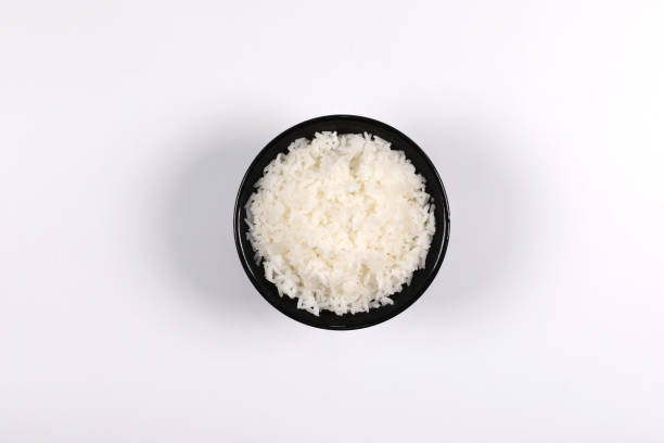 istock Rice in black bowl on white background top view have copy space. 1397493427