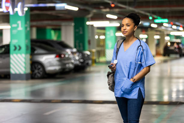 istock Female nurse walking in parking lot alone. 1397495503