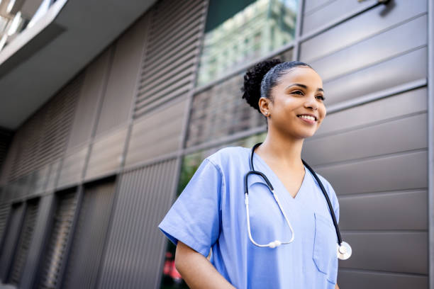istock Hospital worker standing outside hospital while smiling and looking away. 1397495516