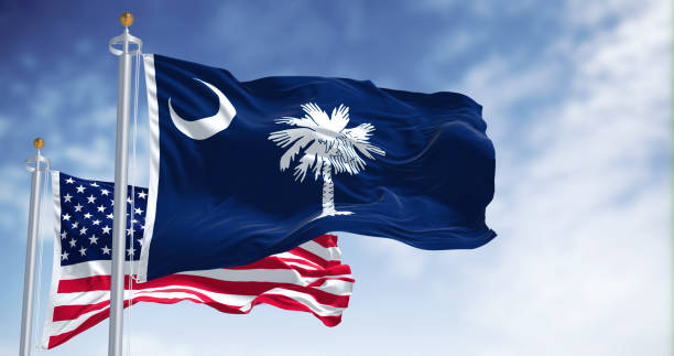 The South Carolina state flag waving along with the national flag of the United States of America stock photo