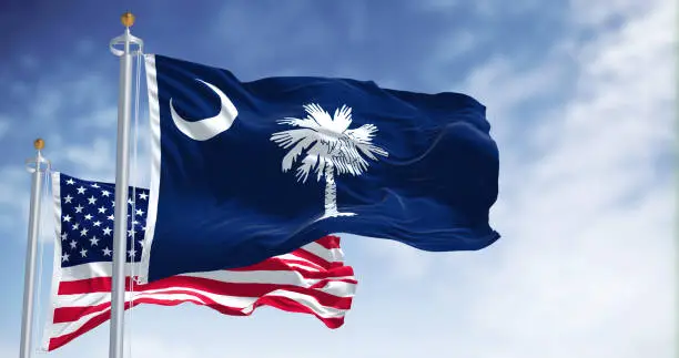 Photo of The South Carolina state flag waving along with the national flag of the United States of America