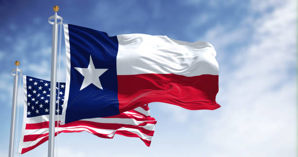 die texanische staatsflagge weht zusammen mit der nationalflagge der vereinigten staaten von amerika - texas state flag stock-fotos und bilder