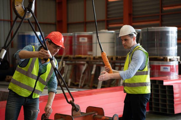 Two young engineers Testing and checking the operation of the semi gantry crane Two young engineers Testing and checking the operation of the over head crane in the factory. gantry crane stock pictures, royalty-free photos & images