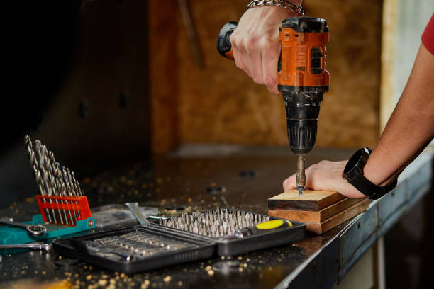 istock Man hand drilling into wood self-tapping screw twisted into place 1397499395