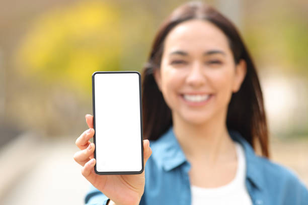 istock Happy woman showing smart phone screen at camera 1397500485
