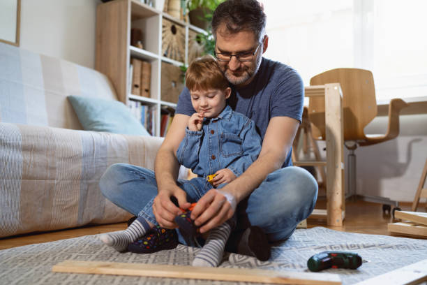 istock Caucasian single father dressing his toddler son, while taking a break from work 1397501115
