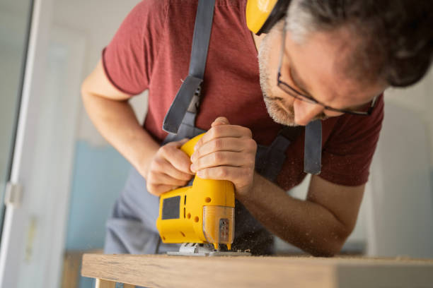 istock While making furniture, Caucasian male carpenter using jigsaw to cut the kitchen countertop 1397501810