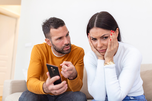 Infidelity. Jealous boyfriend Showing his Cheating girlfriend her Phone Demanding Explanation