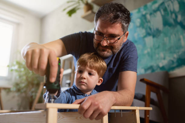 istock While using electric screwdriver, father and son together assembling new wooden furniture 1397501890