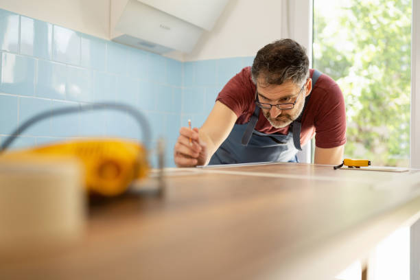 un charpentier caucasien de sexe masculin marque la longueur du comptoir de la cuisine - lenght photos et images de collection