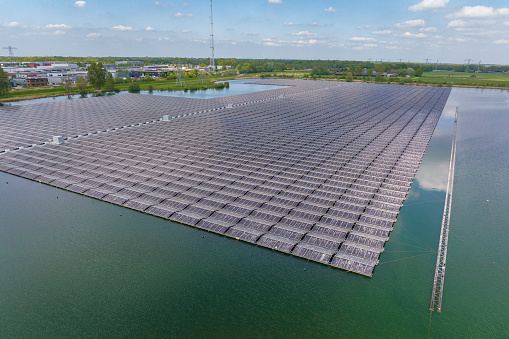 Aerial view on a floating solar farm producing clean renewable electricity energy in Flevoland, Netherlands during a sunny day in winter.